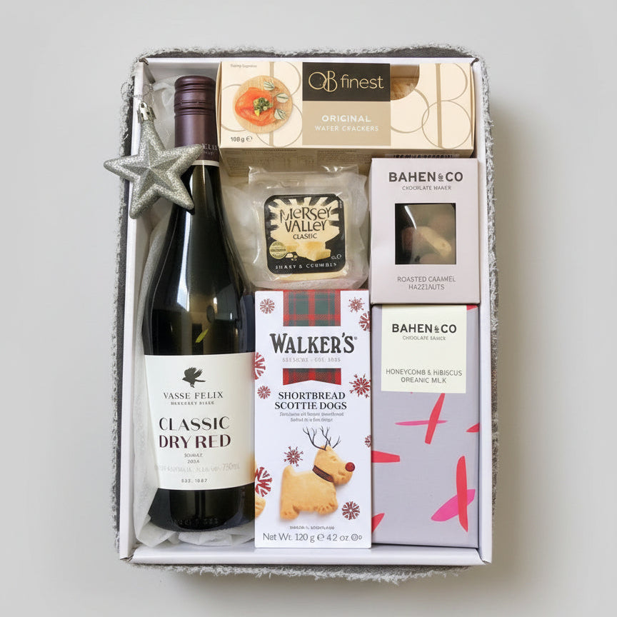 Gift set with a bottle of wine, shortbread, and other snacks in a box.
