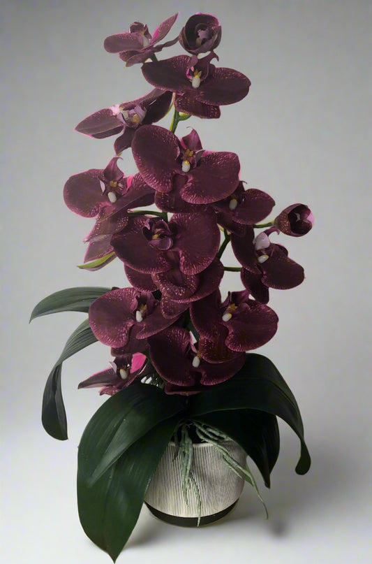 Artificial purple orchid plant in an off white ceramic pot with charcoal pin stripes.