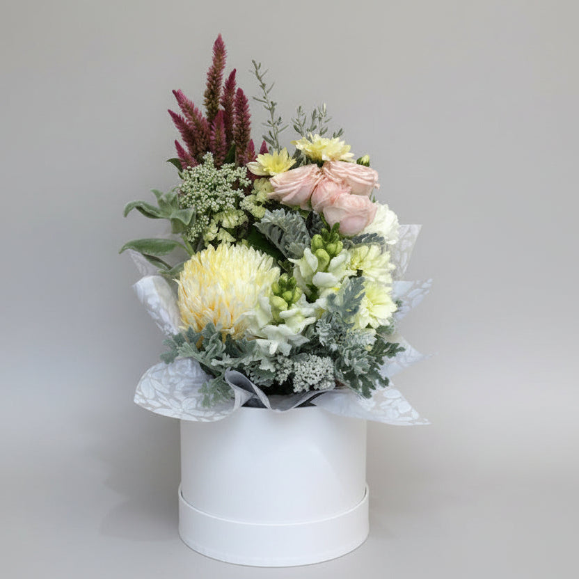 Floral arrangement in a white box on a light gray background