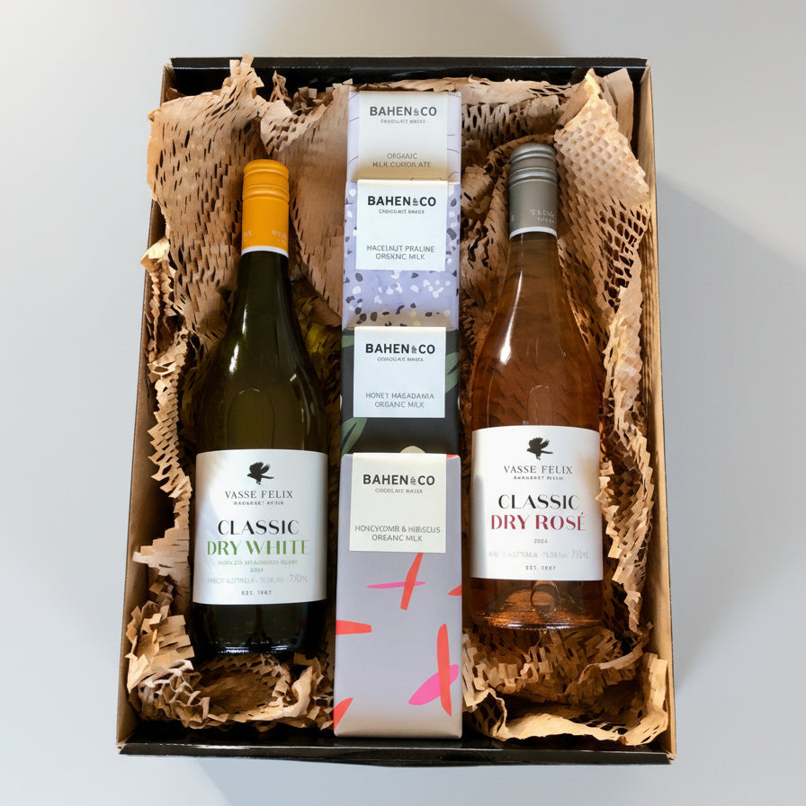 A hamper box with Vasse Felix wine bottles, along with some Bahen & Co. chocolates, presented in a nestled position with bubble wrap. The bottles are labeled and appear to be of high quality.