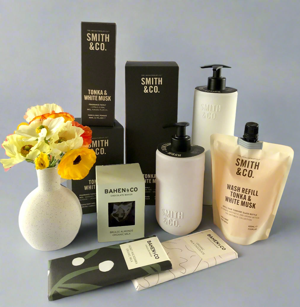 Smith & Co. products including bottles, boxes, and a vase on a white surface.