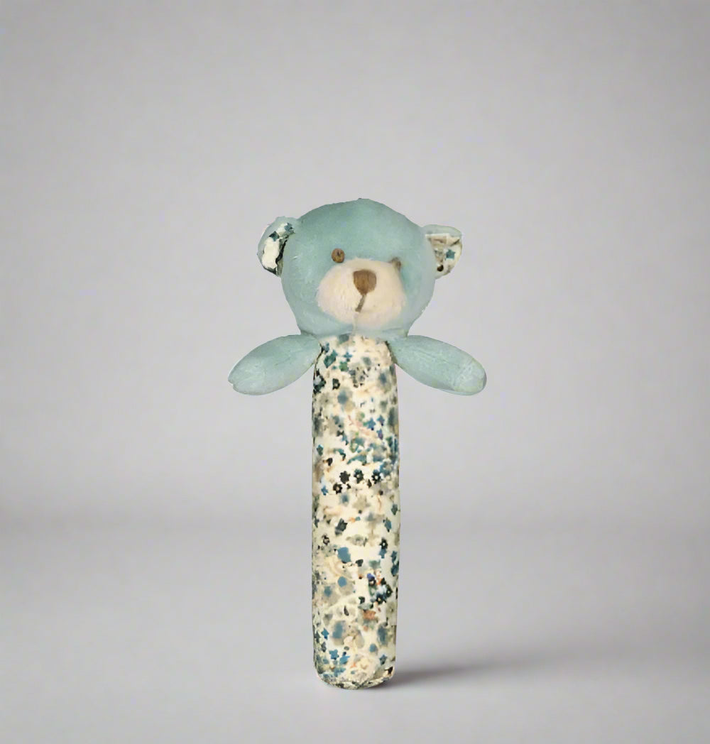 Blue teddy bear rattle with floral pattern on a white background