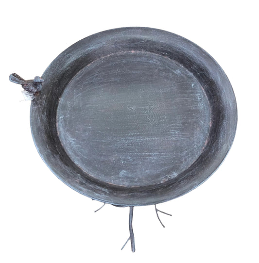 A rustic metal bird feeder on a tree branch style stand.