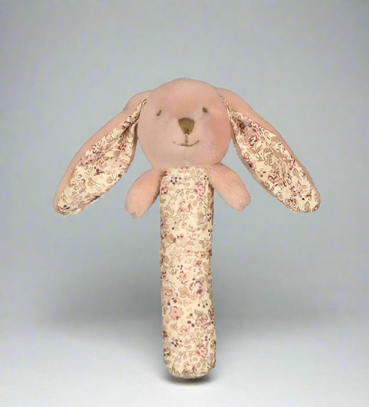 Floral-patterned plush bunny rattle on a white background
