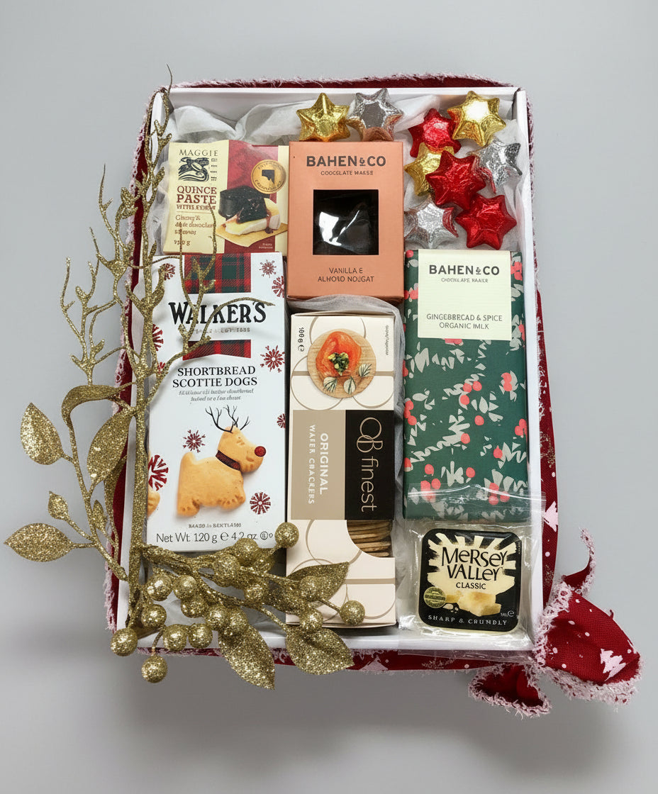 Gift box with various items including Walkers shortbread, Bahen & Co chocolates, and other treats on a wooden surface.