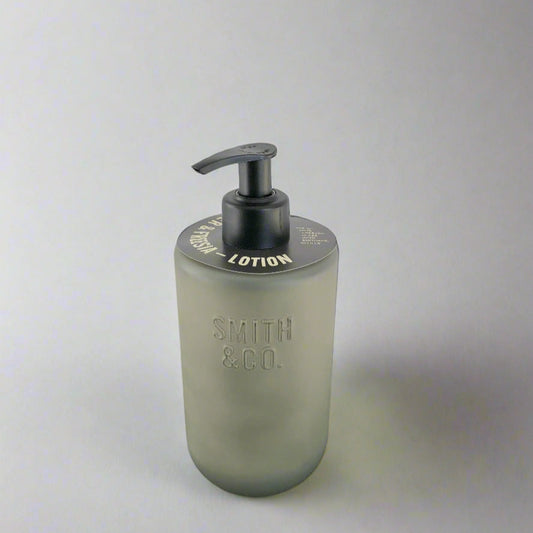 Smith & Co. lotion bottle on a black surface with a white background