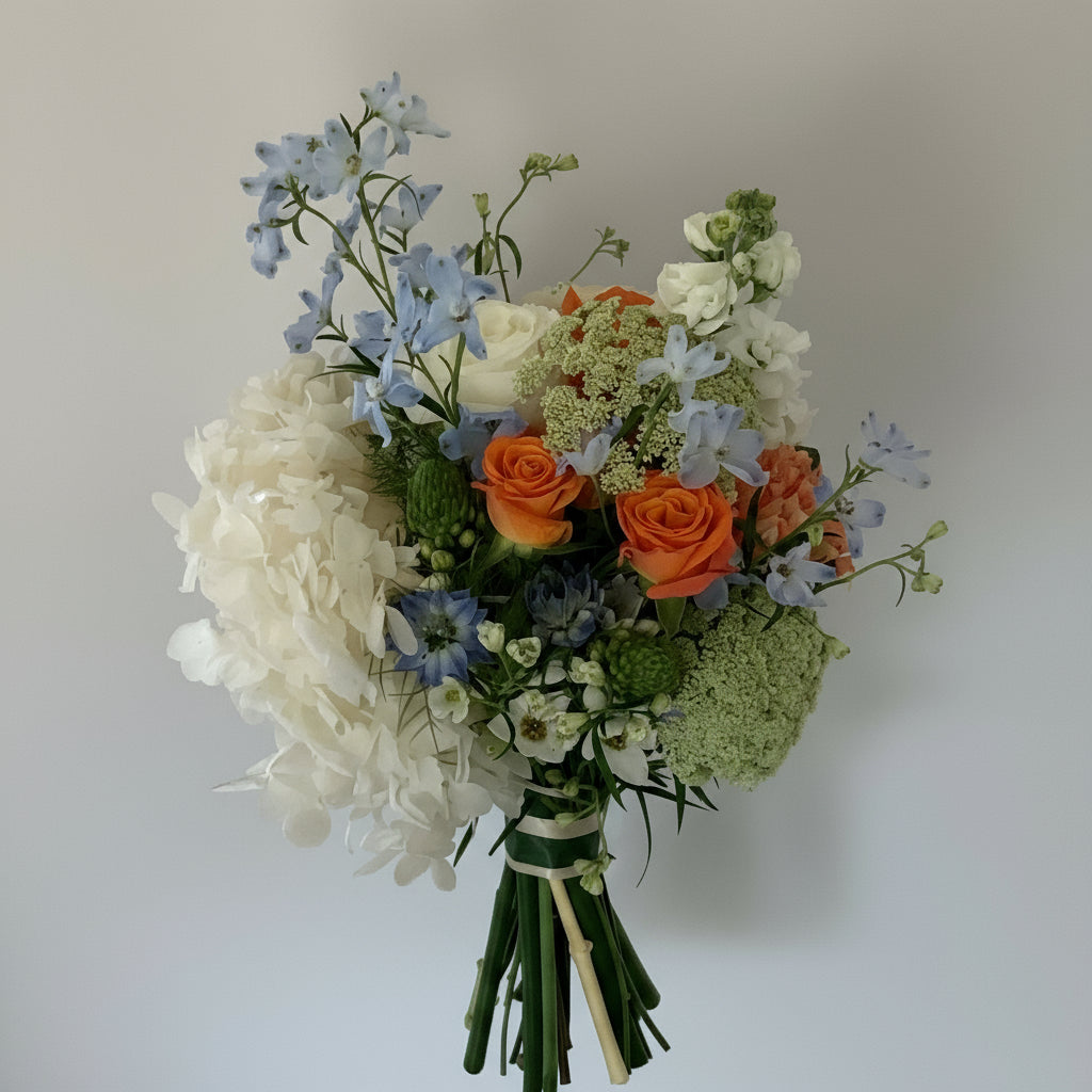 Bouquet of flowers with white, orange, and green colors on a light gray background