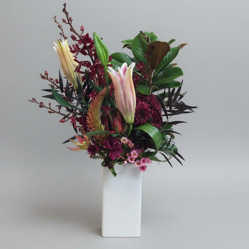 Floral arrangement in a white vase on a gray background