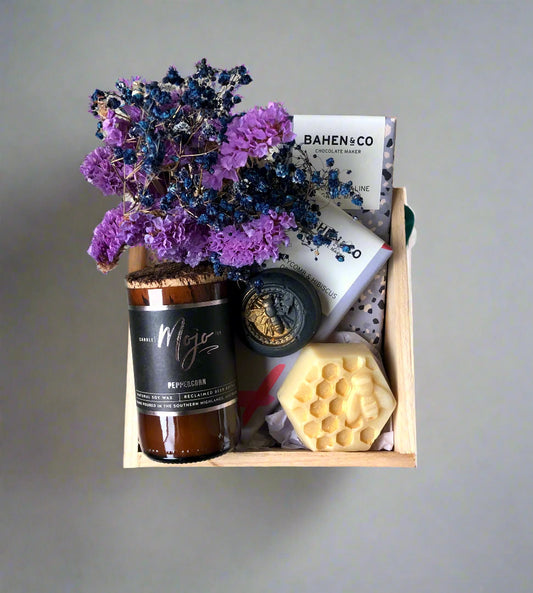 Box with a candle, soap, chocolates and flowers 