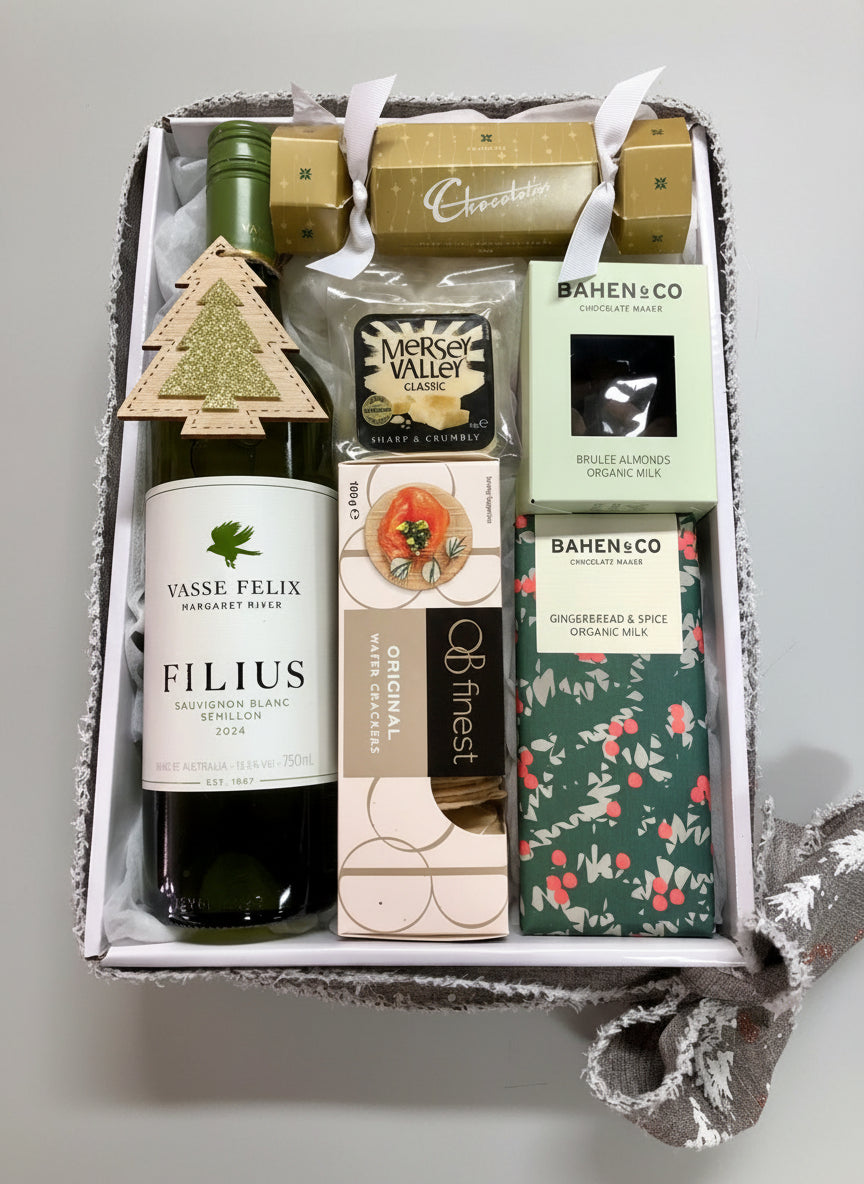 Gift box with Vasse Felix wine, chocolate bars, and other items on a wooden surface