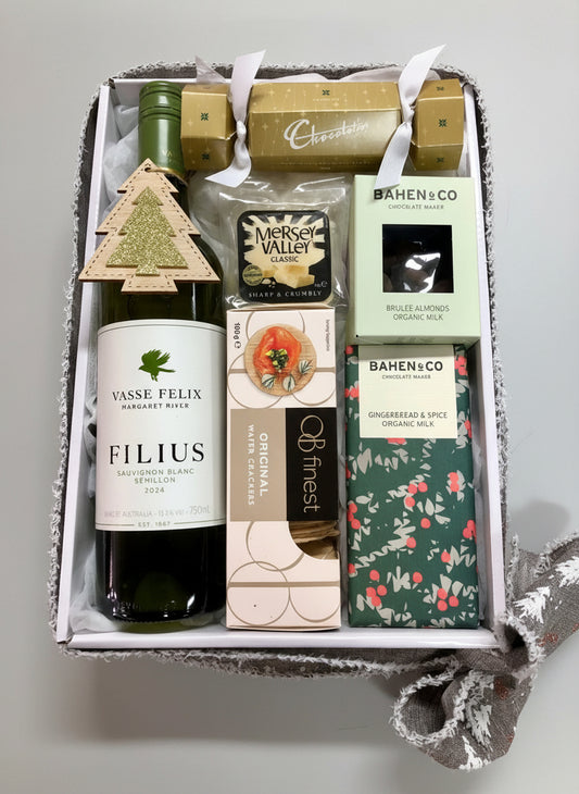 Gift box with Vasse Felix wine, chocolate bars, and other items on a wooden surface