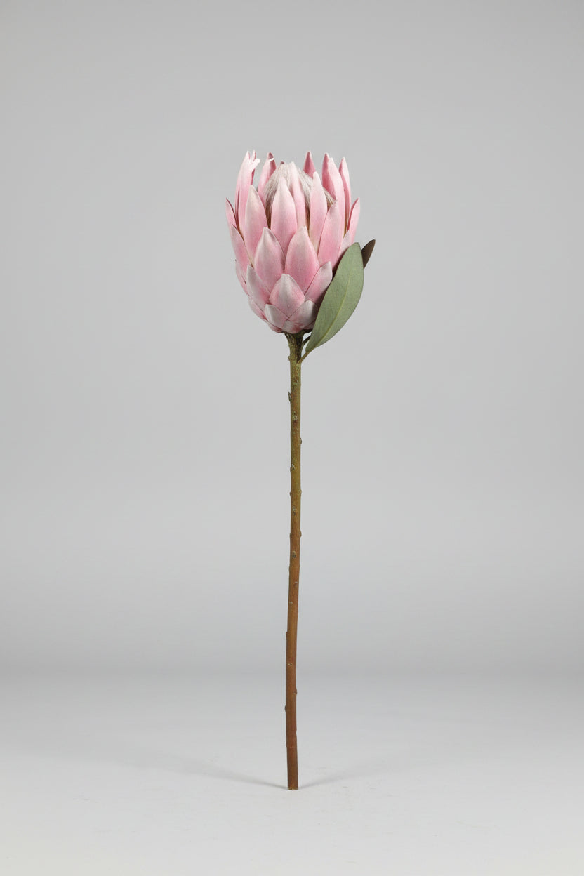 Pink artificial flower on a concrete surface