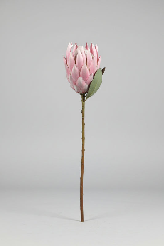 Pink artificial flower on a concrete surface