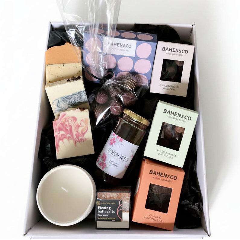 Gift box with various items including candles, soap, and bath bombs from BAHEN & CO on a white background.