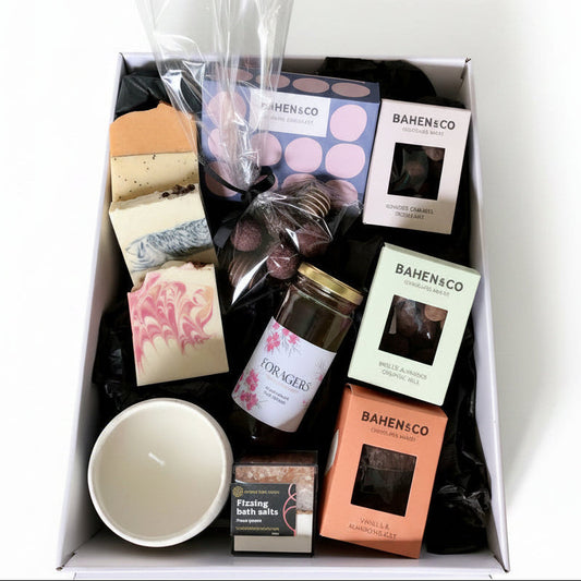 Gift box with various items including candles, soap, and bath bombs from BAHEN & CO on a white background.
