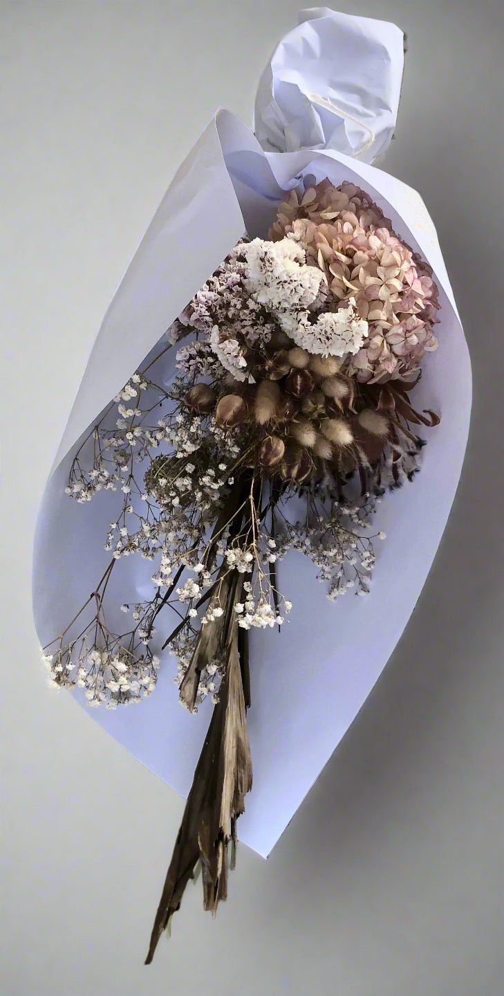 Bouquet of dried flowers on a white paper wrap 