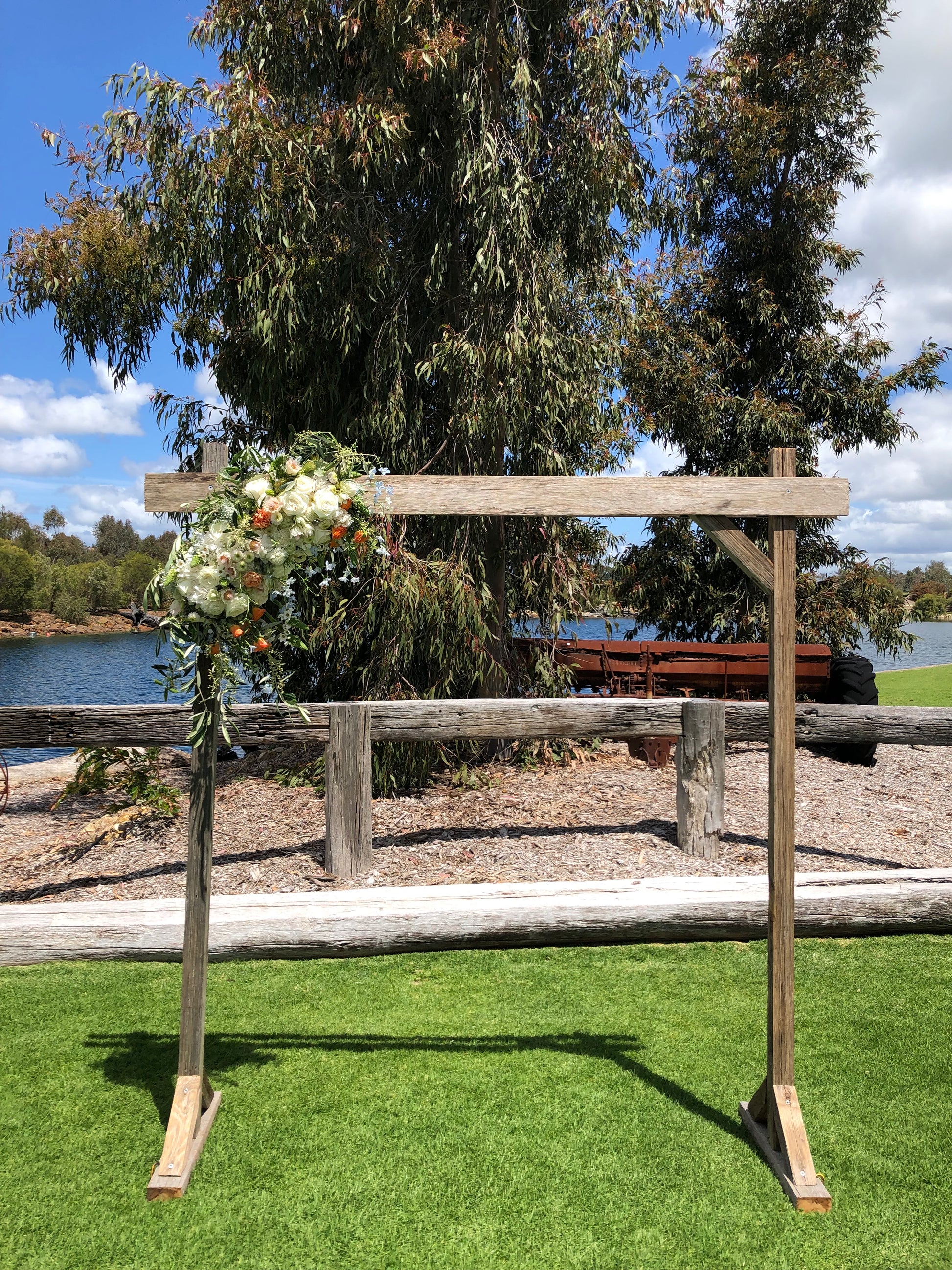 Wooden cross with floral arrangement against a natural background