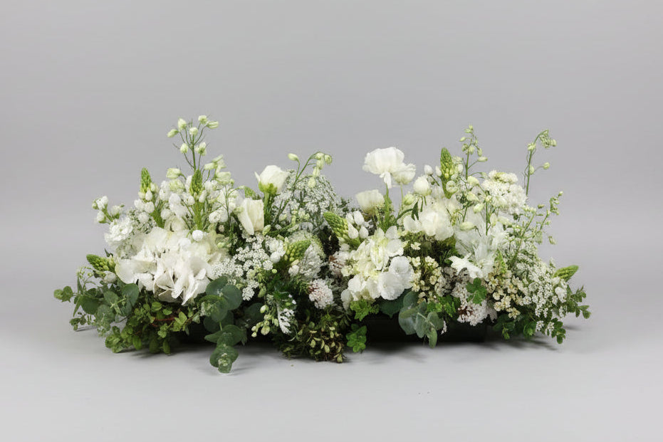 Floral arrangement on a wooden table with a neutral background
